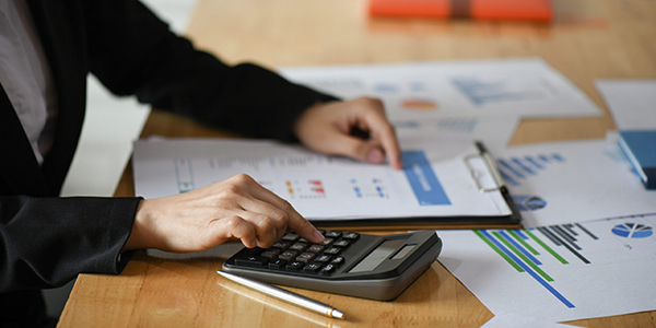 Cropped shot of Accounting staff are using calculators and graph Cropped shot of Accounting staff are using calculators and graph